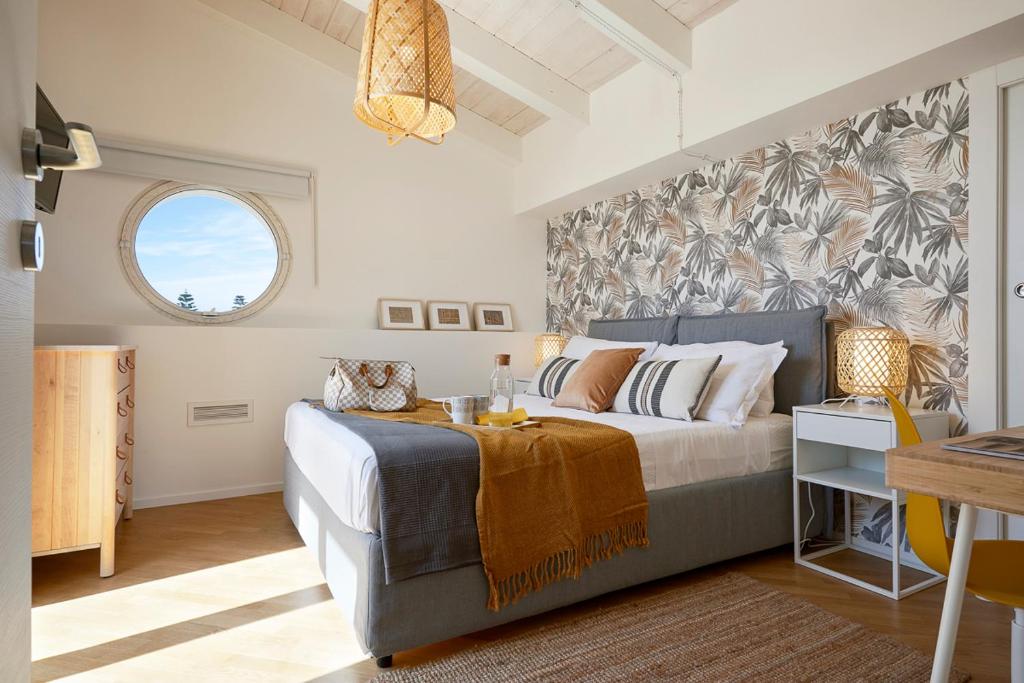 une chambre avec un grand lit et une fenêtre dans l'établissement Villa Gemma mare e piscina riscaldata, à Santa Maria Del Focallo