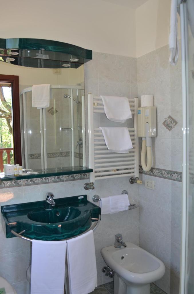 une salle de bain avec un lavabo vert et des toilettes dans l'établissement Hotel Villa Cipro, sur le Lido de Venise
