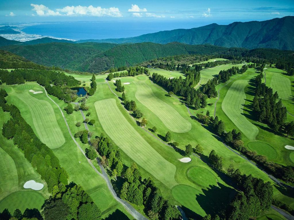 - une vue aérienne sur un parcours de golf avec des montagnes en arrière-plan dans l'établissement Hakone Yunohana Prince Hotel, à Hakone