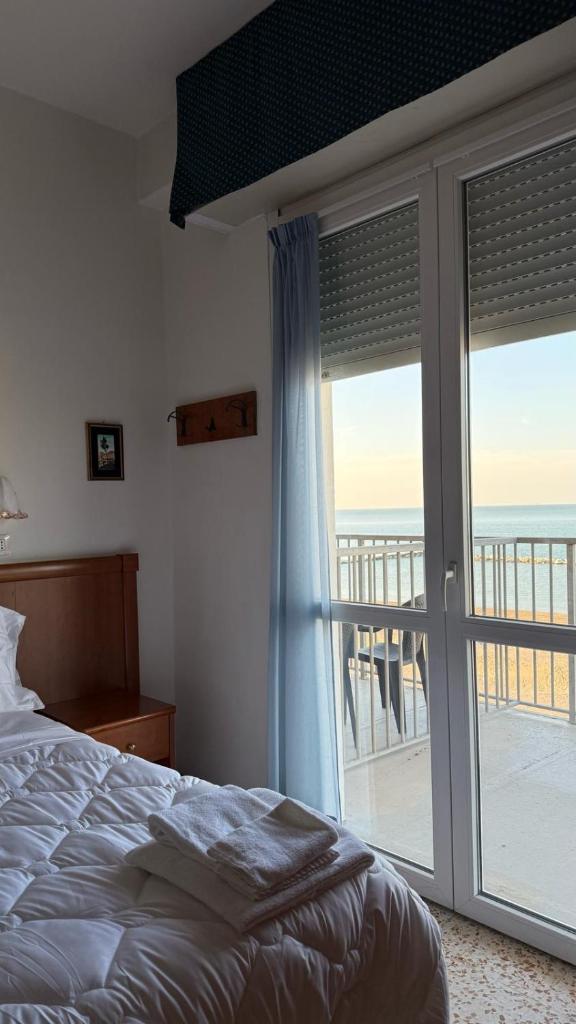 une chambre avec un lit et une porte coulissante en verre dans l'établissement Diplomat Marine, à Cattolica