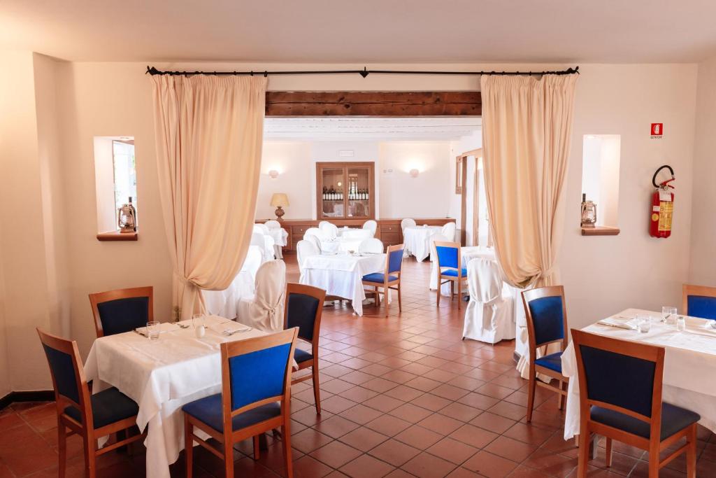 une salle à manger avec des tables blanches et des chaises bleues dans l'établissement Hotel Palumbalza Porto Rotondo, à Porto Rotondo 40 autres photos