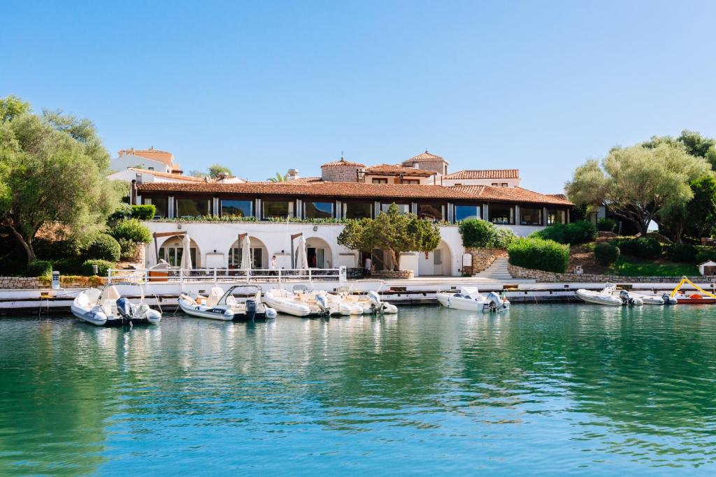 une maison sur l'eau avec des bateaux amarrés dans l'établissement Hotel Palumbalza Porto Rotondo, à Porto Rotondo