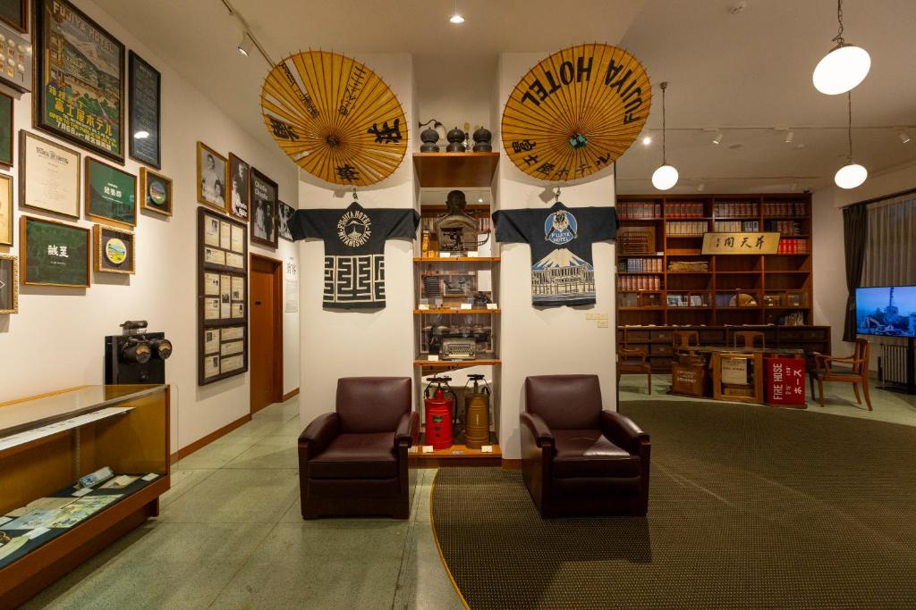 un magasin avec deux chaises et parasols sur le mur dans l'établissement Fujiya Hotel, à Hakone