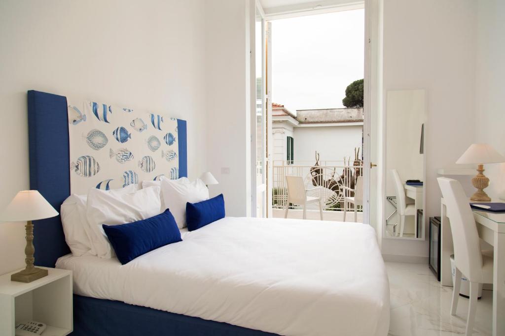 - une chambre avec un lit blanc aux accents bleus dans l'établissement Hotel Crawford, à Sant'Agnello 28 autres photos