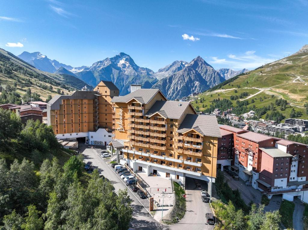 une vue aérienne sur un hôtel avec des montagnes en arrière-plan dans l'établissement Belambra Clubs Les 2 Alpes Les Crêtes, à Les Deux Alpes