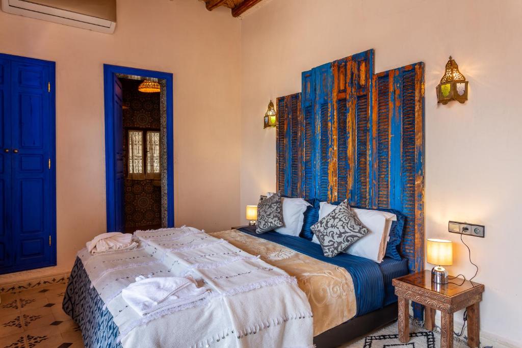 - une chambre avec un lit à tête bleue dans l'établissement Riad Bianca Marrakech, à Marrakech