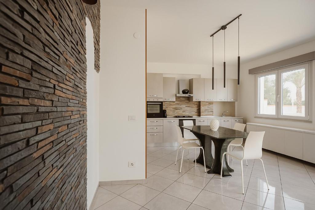une cuisine et une salle à manger avec un mur de briques dans l'établissement AR Palace Hotel - Palermo, à Isola delle Femmine