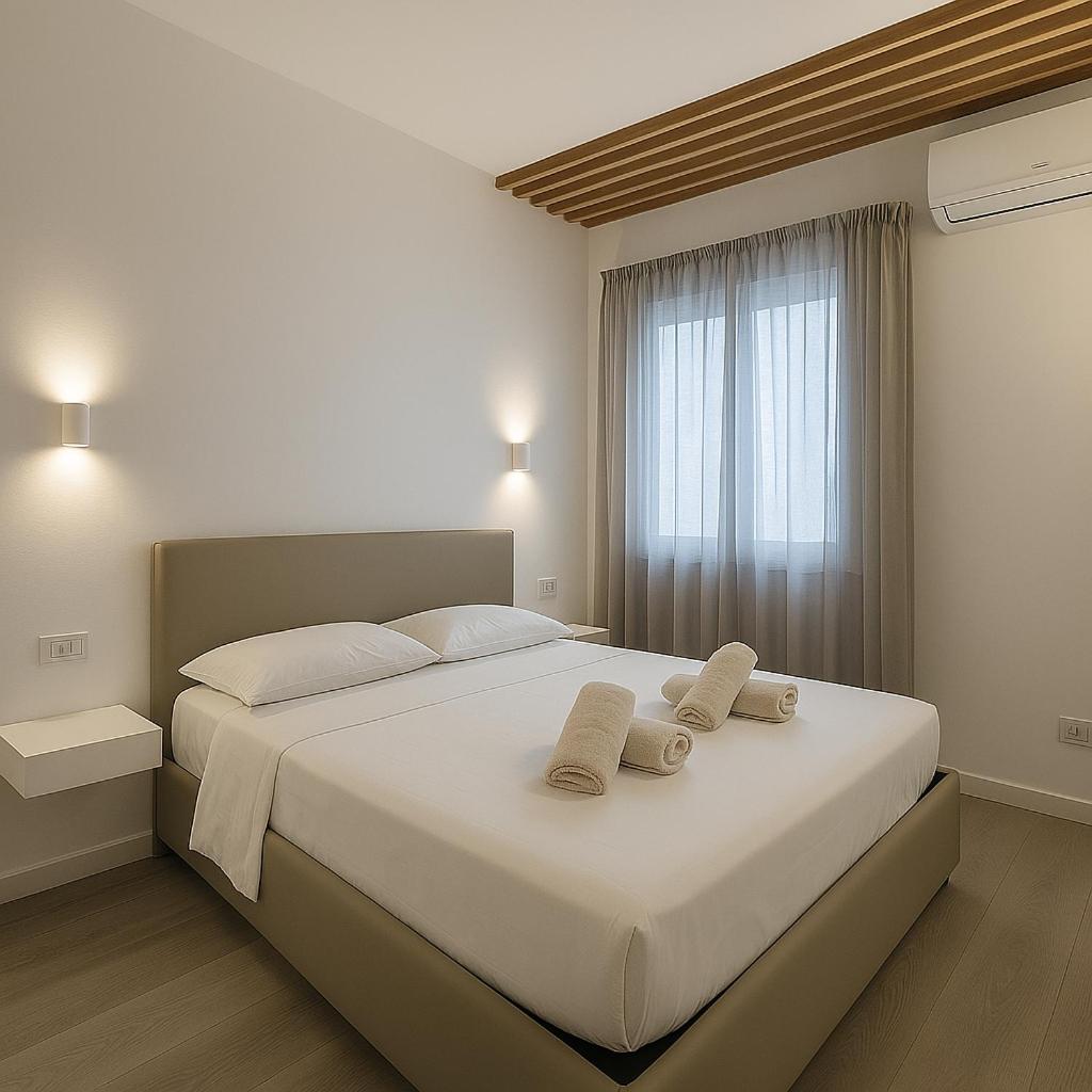 une chambre avec un grand lit avec deux serviettes dessus dans l'établissement AR Palace Hotel - Palermo, à Isola delle Femmine