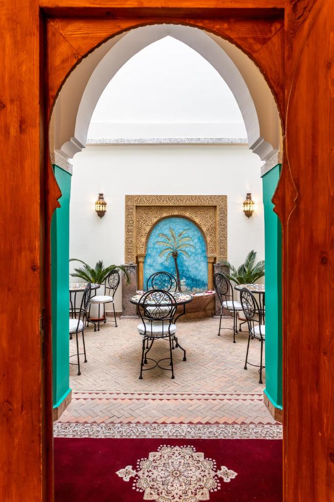 une arche avec des tables et des chaises ainsi qu'une cheminée dans l'établissement Riad Bianca Marrakech, à Marrakech