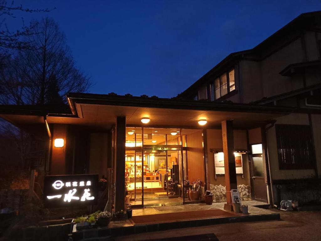 un bâtiment avec un panneau devant lui la nuit dans l'établissement 一水荘, à Gosen