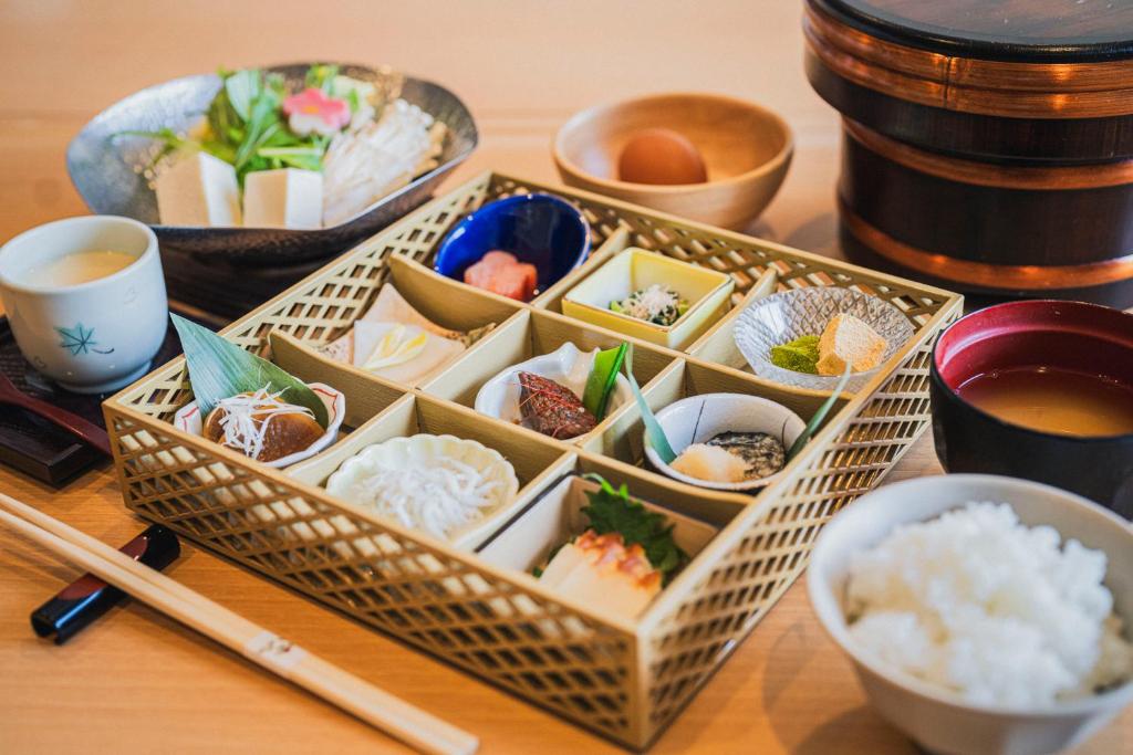 une table recouverte de bols de sushis et de baguettes dans l'établissement Shinzan Kinosaki, à Toyooka