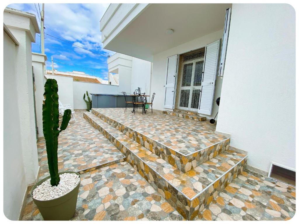 une maison avec un cactus sur une terrasse dans l'établissement villa adua, à Torre Santa Sabina