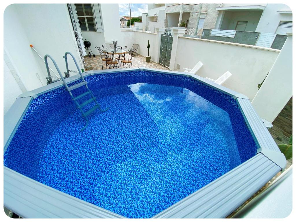 - une piscine d'eau bleue au-dessus d'une maison dans l'établissement villa adua, à Torre Santa Sabina