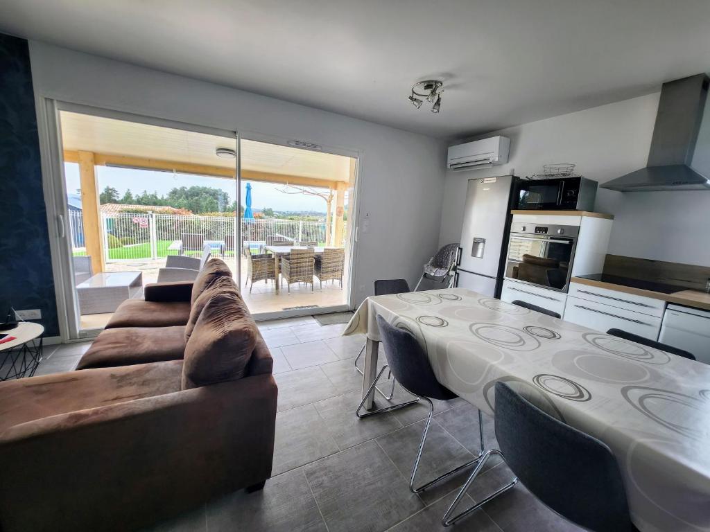 un salon avec une table et un canapé dans l'établissement En Ardèche, gîte L'Odalys climatisé avec sa piscine privée et chauffée, à Joyeuse 20 autres photos