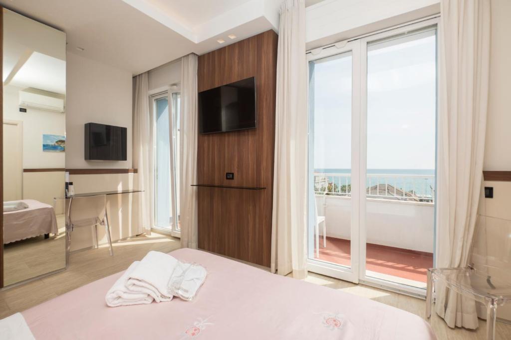 une chambre d'hôtel avec un lit et une grande fenêtre dans l'établissement Hotel Mondial, à Porto Recanati