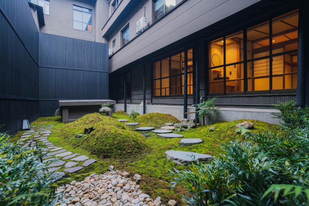 un jardin en face d'un bâtiment avec un banc dans l'établissement Shinzan Kinosaki, à Toyooka 37 autres photos