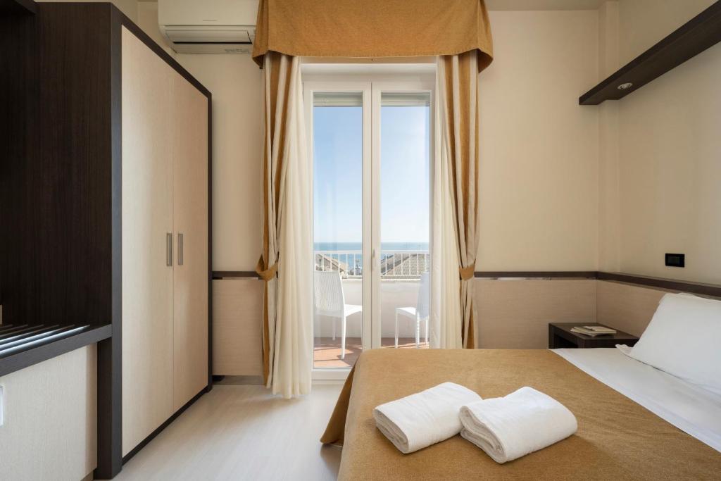 - une chambre avec un lit et 2 serviettes blanches dans l'établissement Hotel Mondial, à Porto Recanati