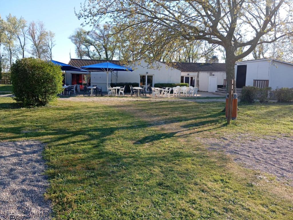 une maison avec une table et un parasol dans la cour dans l'établissement Mobil-Home Provence, à Cheval-Blanc
