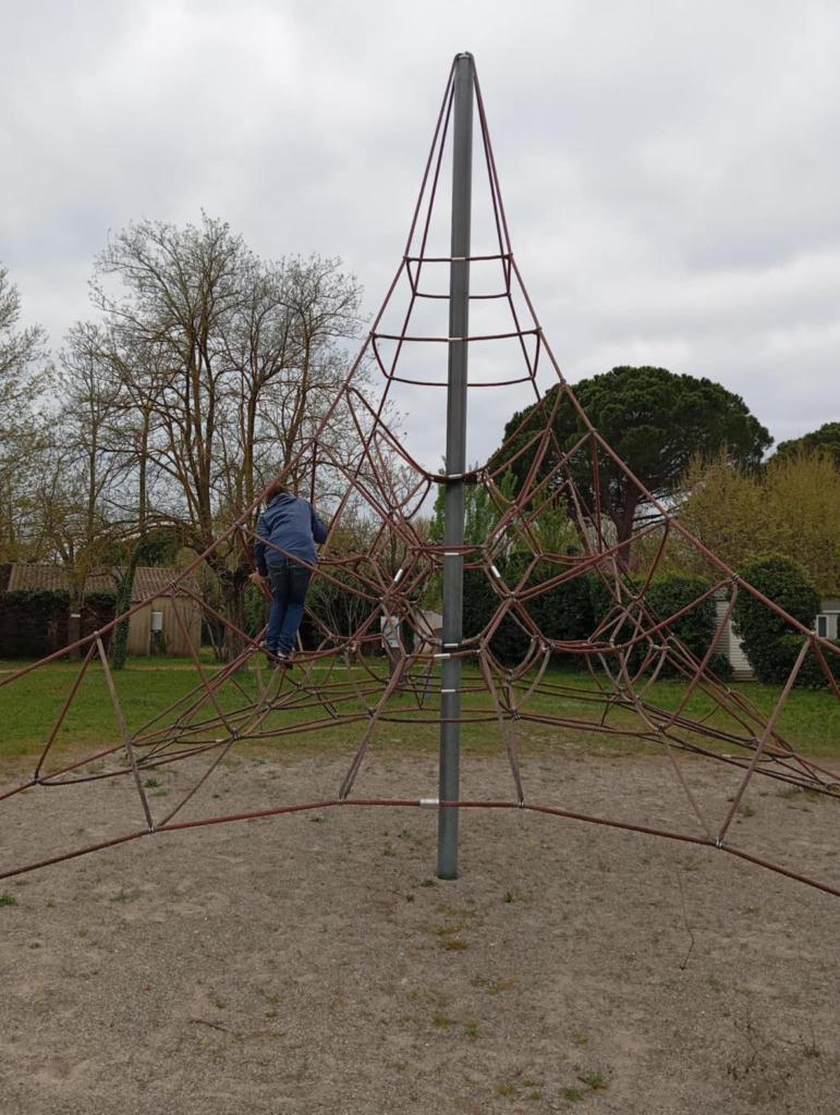Un homme construit une toile d'araignées dans un parc dans l'établissement Mobil-Home Provence, à Cheval-Blanc