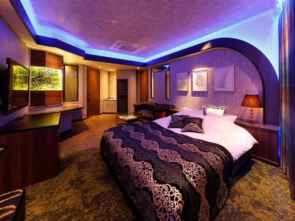 - une chambre avec un grand lit et un plafond violet dans l'établissement Hotel Le Club PLUS 1 福岡新宮 -Adult Only-, à Shingū