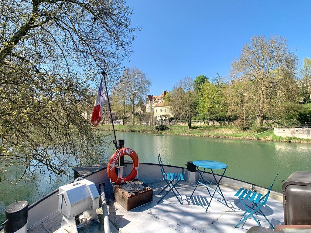 - un bateau avec des chaises et une table sur l'eau dans l'établissement La Marquise, à Melun