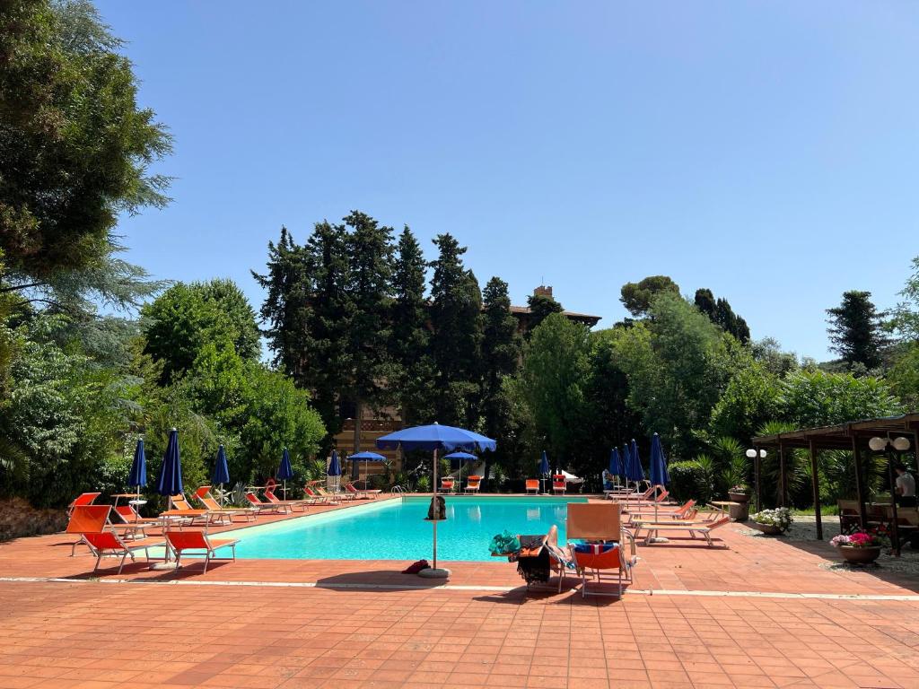 une piscine avec des chaises et des parasols à côté dans l'établissement Park Hotel Napoleone, à Portoferraio