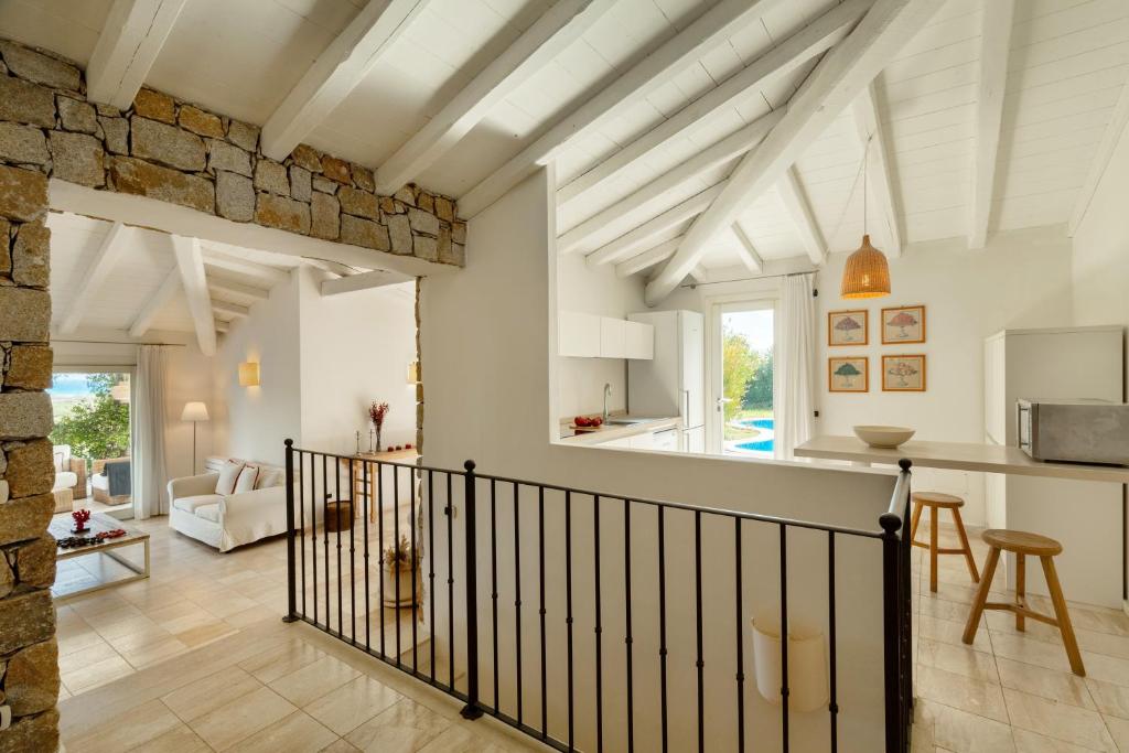 Il comprend une cuisine et un salon avec un mur en pierre. dans l'établissement Villa Gelsomino a soli 500 mt dal mare con piscina privata e vista mare, à Castiadas