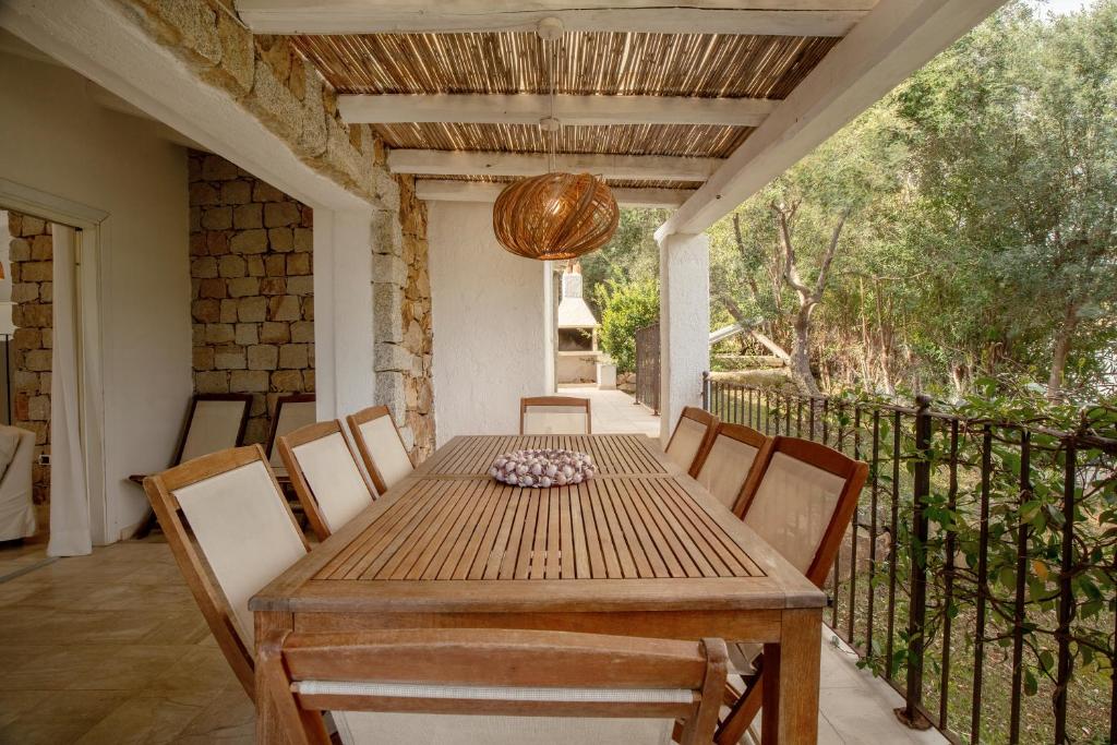 une salle à manger avec une table et des chaises sur un balcon dans l'établissement Villa Gelsomino a soli 500 mt dal mare con piscina privata e vista mare, à Castiadas