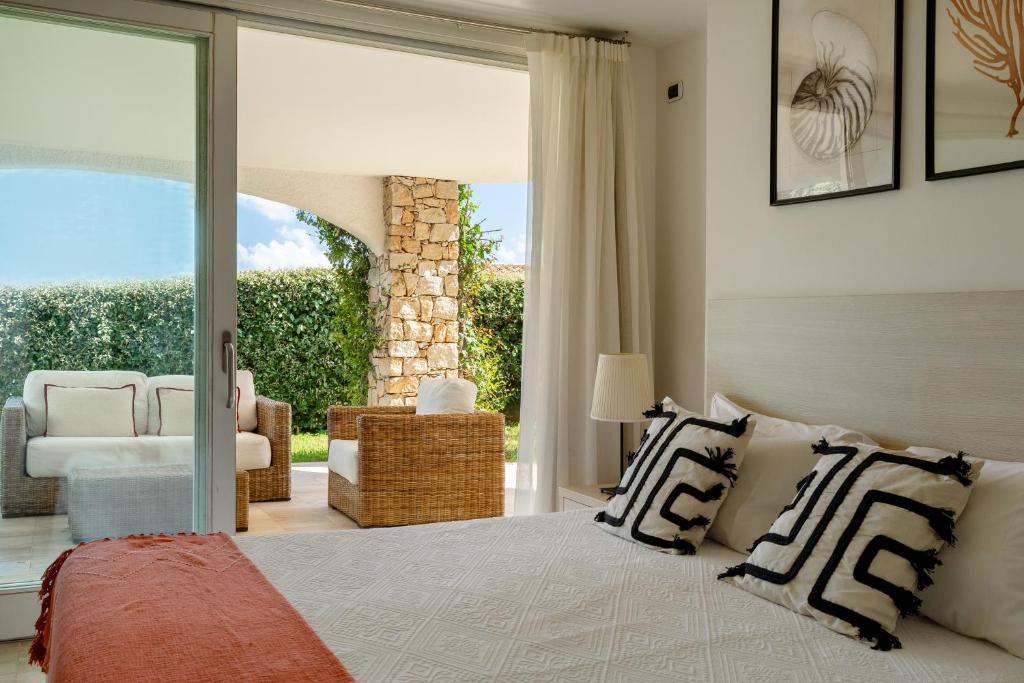 une chambre avec un lit et une grande fenêtre dans l'établissement Villa Gelsomino a soli 500 mt dal mare con piscina privata e vista mare, à Castiadas
