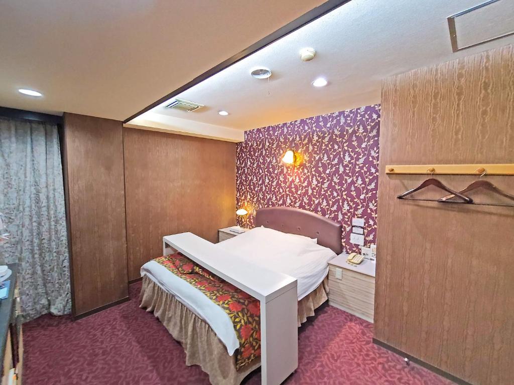 Cette chambre comprend un lit et un lavabo. dans l'établissement Pal Annex Nakatsu (Love Hotel), à Nakatsu