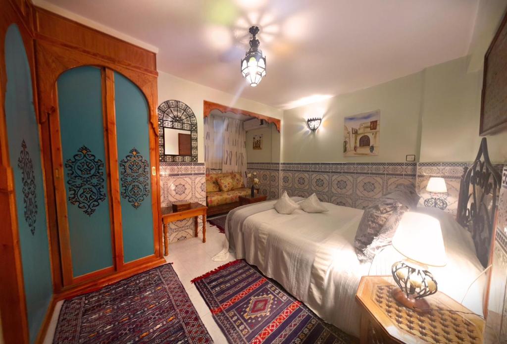 - une chambre avec un lit et une chambre avec un canapé dans l'établissement Riad Atika Mek, à Meknès