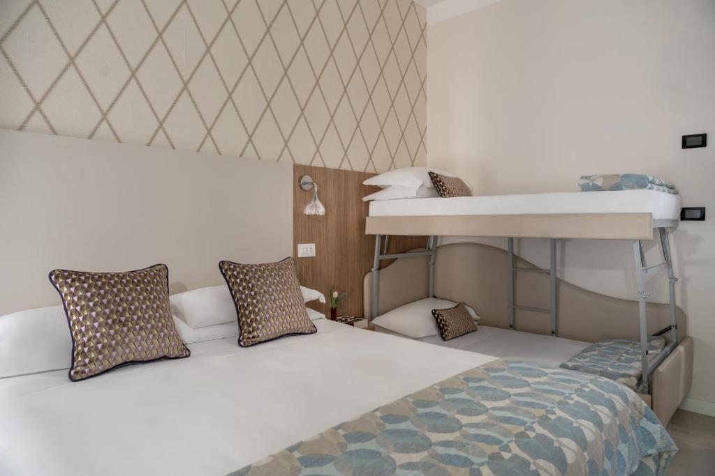 une chambre avec un lit et un lit superposé dans l'établissement Hotel Calypso- Rimini Marina Centro, à Rimini