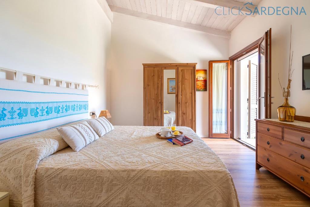 une chambre avec un grand lit et une commode dans l'établissement ClickSardegna Villa dei Limoni with pool close to the beach, à Fertilia 58 autres photos