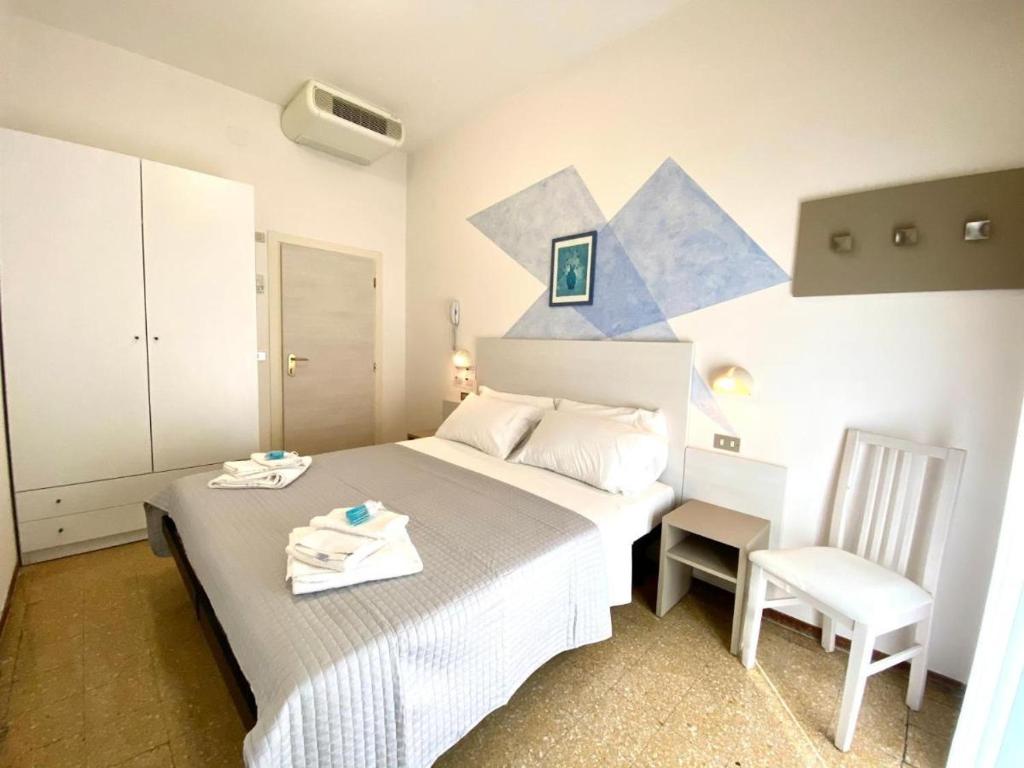une petite chambre avec un lit et une chaise dans l'établissement Alevon Hotel, à Rimini