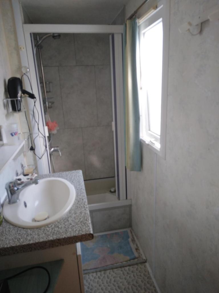 une salle de bain avec un lavabo et une douche dans l'établissement les marguerites, à Mimizan