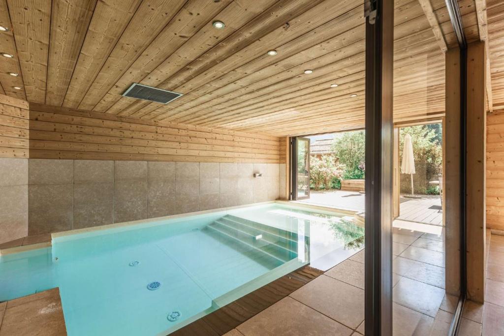 - une piscine dans une maison dotée d'un plafond en bois dans l'établissement Chalet le 4 - numéro 4, au Grand-Bornand