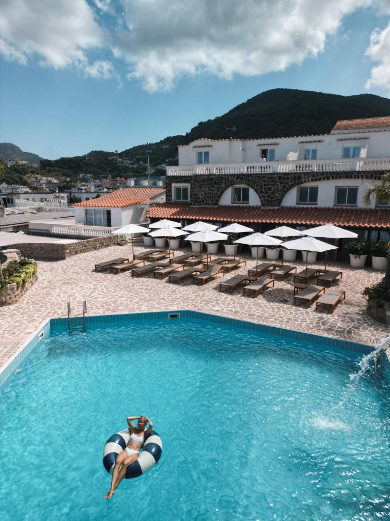 une femme pose sur un ballon dans une piscine dans l'établissement Pagoda Lifestyle Hotel, à Ischia