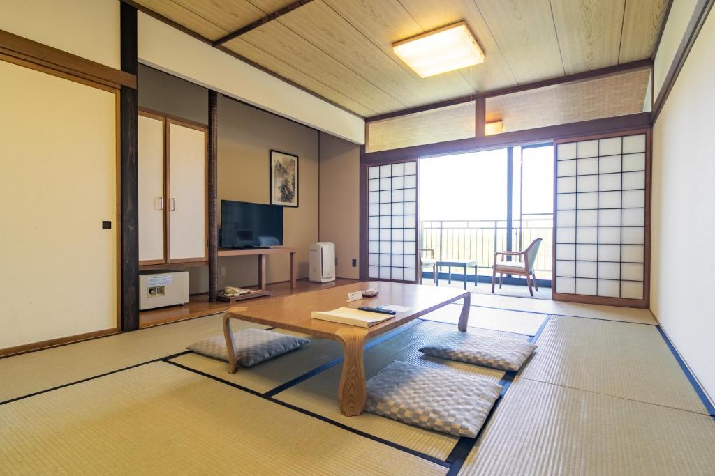 un salon avec une table et une grande fenêtre dans l'établissement Tokachi Makubetsu Onsen Grandvrio Hotel, à Obihiro