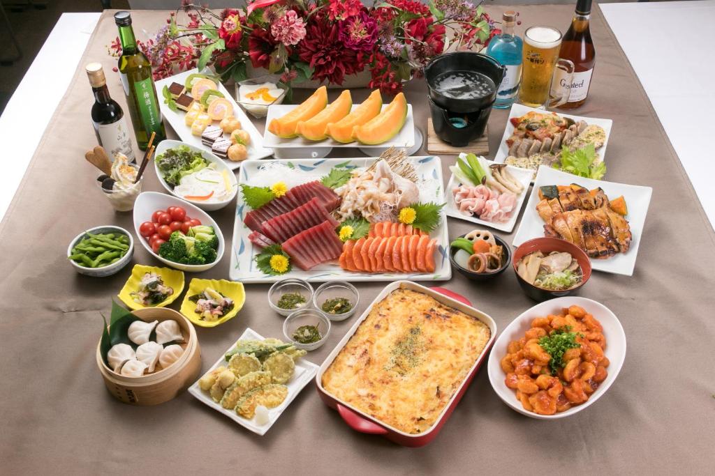 une table garnie de nombreux types d'aliments différents dans l'établissement Tokachi Makubetsu Onsen Grandvrio Hotel, à Obihiro