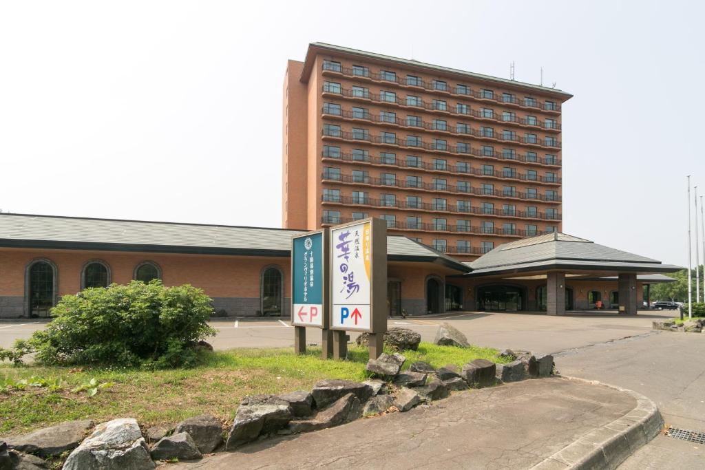 un bâtiment d'hôtel avec une enseigne devant dans l'établissement Tokachi Makubetsu Onsen Grandvrio Hotel, à Obihiro