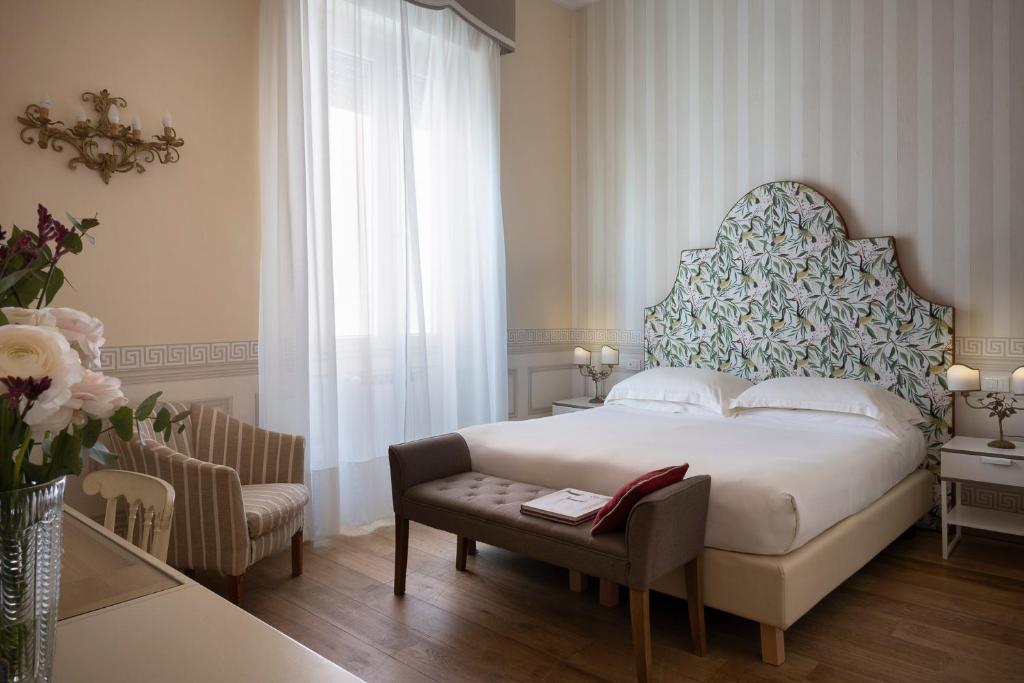 une chambre avec un lit, une table et une chaise dans l'établissement Palace Hotel, à Viareggio
