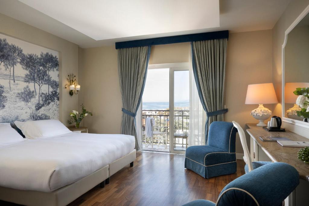 une chambre d'hôtel avec un lit, un bureau et une fenêtre dans l'établissement Palace Hotel, à Viareggio
