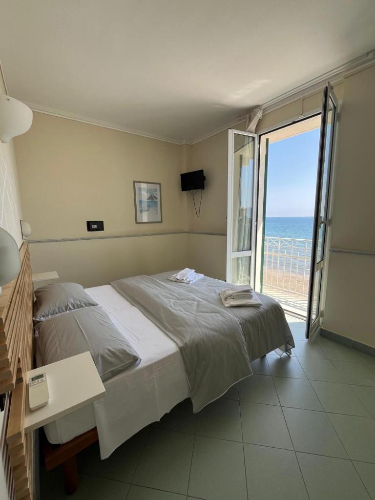 une chambre avec un lit et une vue sur l'océan dans l'établissement Hotel Gandolfo, à Alassio