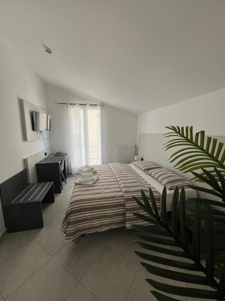 une grande chambre avec un grand lit et un bureau dans l'établissement Hotel Gandolfo, à Alassio