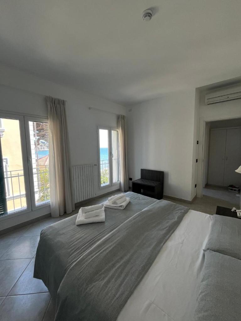 une chambre avec un grand lit avec deux serviettes dessus dans l'établissement Hotel Gandolfo, à Alassio 5 autres photos