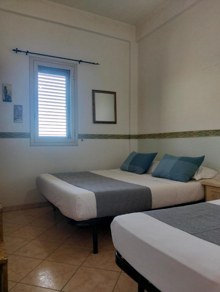 deux lits dans une chambre avec une fenêtre dans l'établissement HOME 65 Seafront With Private Pool, à Villaggio Azzurro 20 autres photos