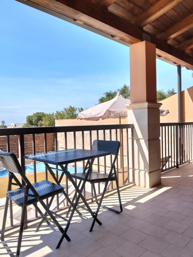 une table et deux chaises sur un balcon dans l'établissement HOME 65 Seafront With Private Pool, à Villaggio Azzurro