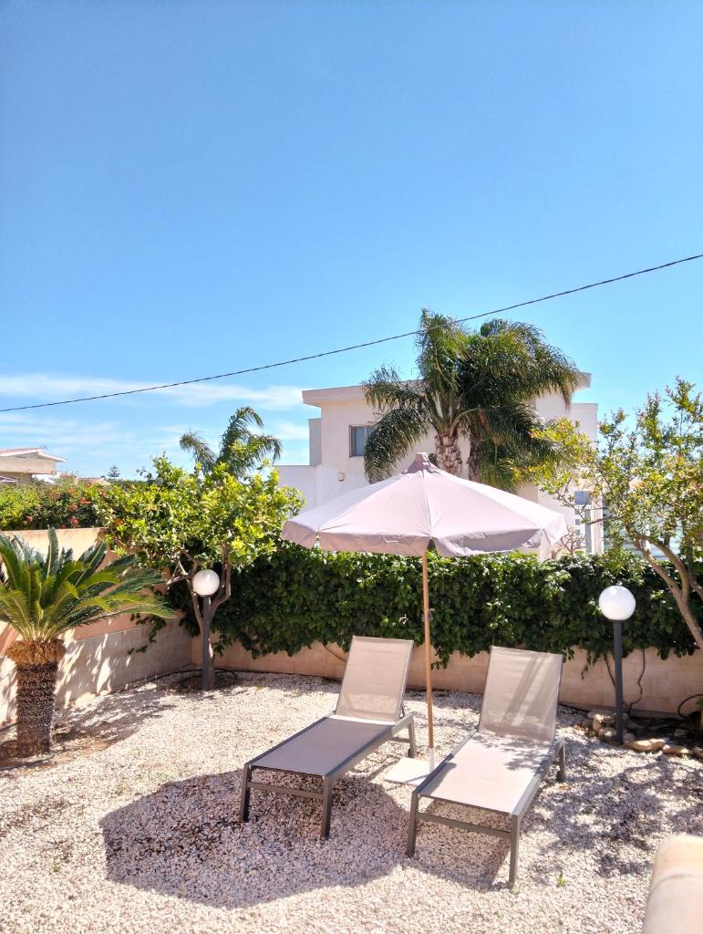 - 2 chaises et un parasol sur la terrasse dans l'établissement HOME 65 Seafront With Private Pool, à Villaggio Azzurro