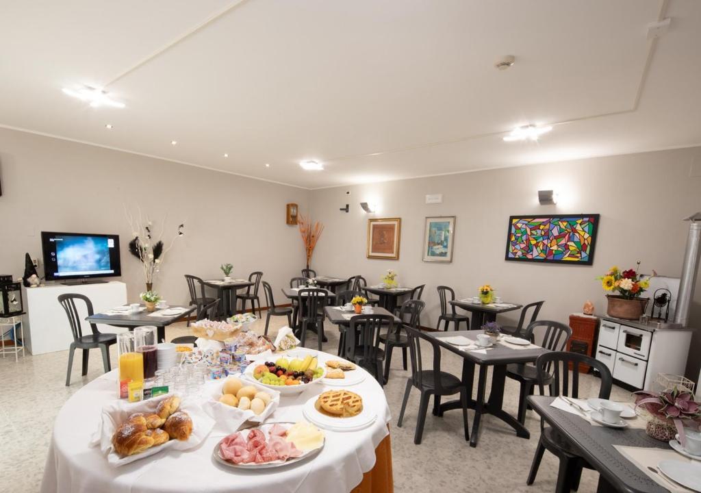 - une salle avec des tables et des chaises avec de la nourriture dans l'établissement EURO b&b, à Cattolica