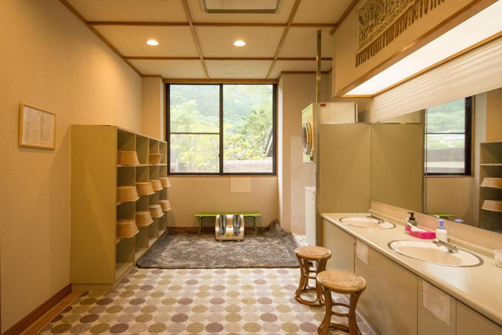La salle de bains est pourvue de 2 lavabos et de 2 tabourets. dans l'établissement Akasawa Onsen Ryokan, à Nasushiobara